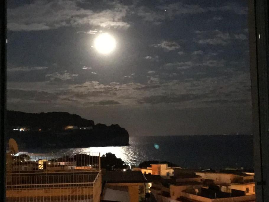 Una luna llena elevándose sobre el océano por la noche en I datteri Bilocale ristrutturato a meno di 300 mt dal mare en Gaeta