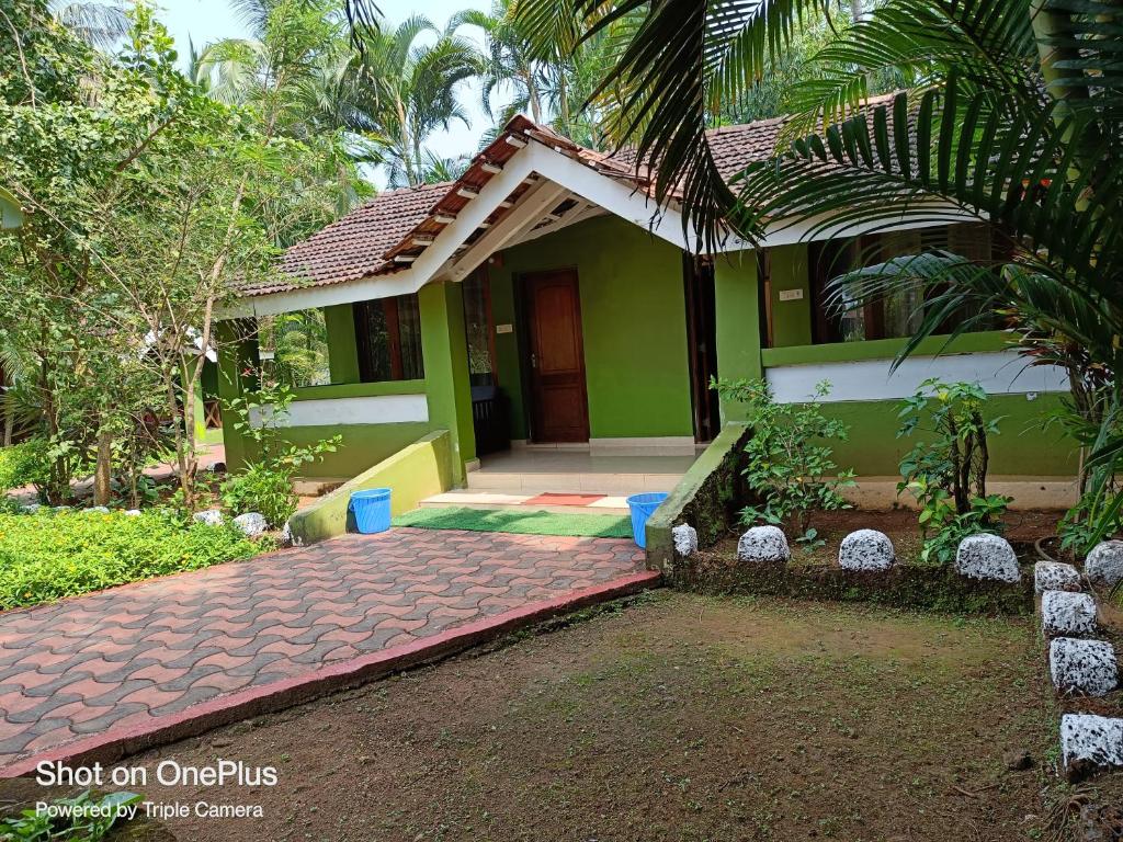 a green and white house with a driveway at Dunhill Beach Resort in Agonda