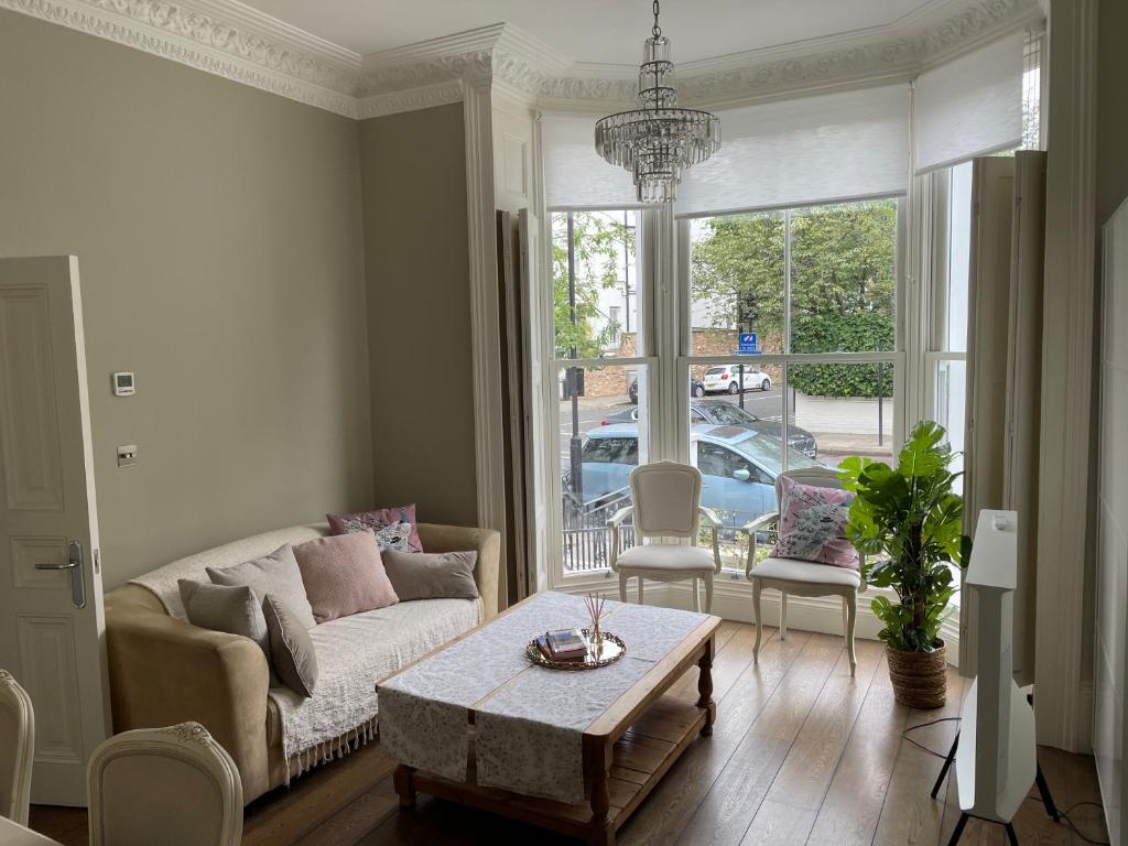 a living room with a couch and a table at Stylish 3-bedroom flat in Kensington in London
