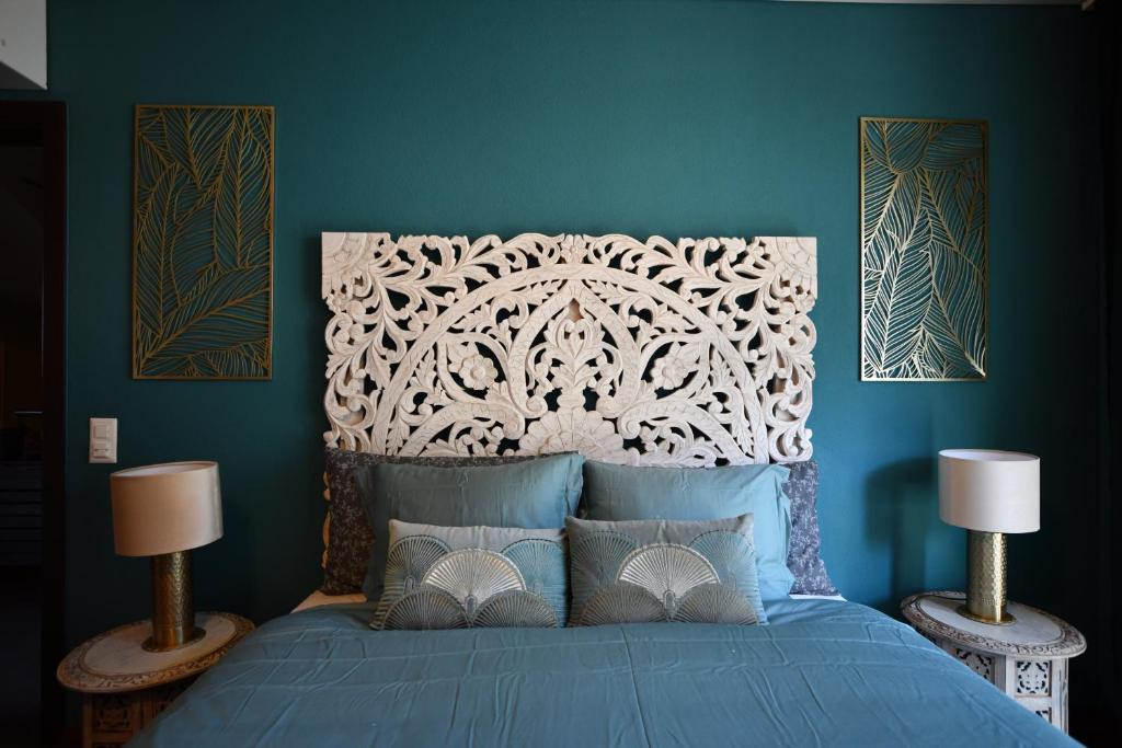 a blue bedroom with a bed with a white headboard at Boutique B&B and Wellness la Casa dei 5 Elementi in Giubiasco