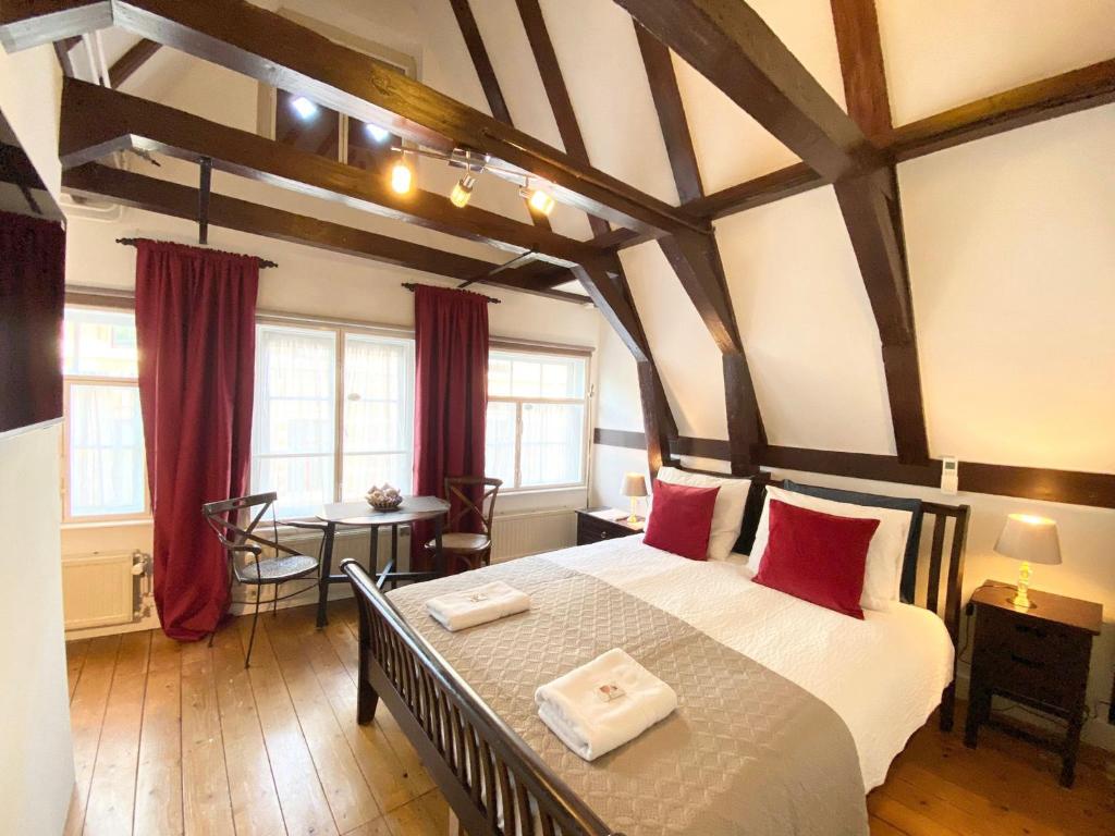een slaapkamer met een groot bed met rode kussens bij Flinder Amsterdam in Amsterdam