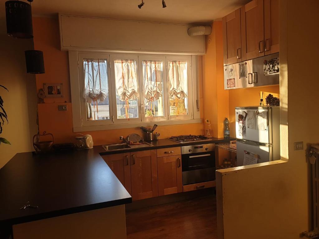 une cuisine avec des placards en bois et un comptoir noir dans l'établissement Appartamento Il Girasole, à Casatenovo