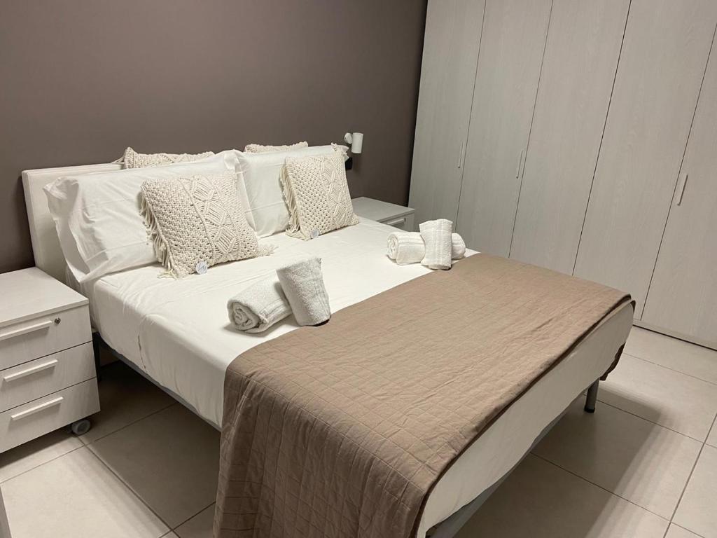 una camera da letto con letto, lenzuola e cuscini bianchi di suite48 a Bari