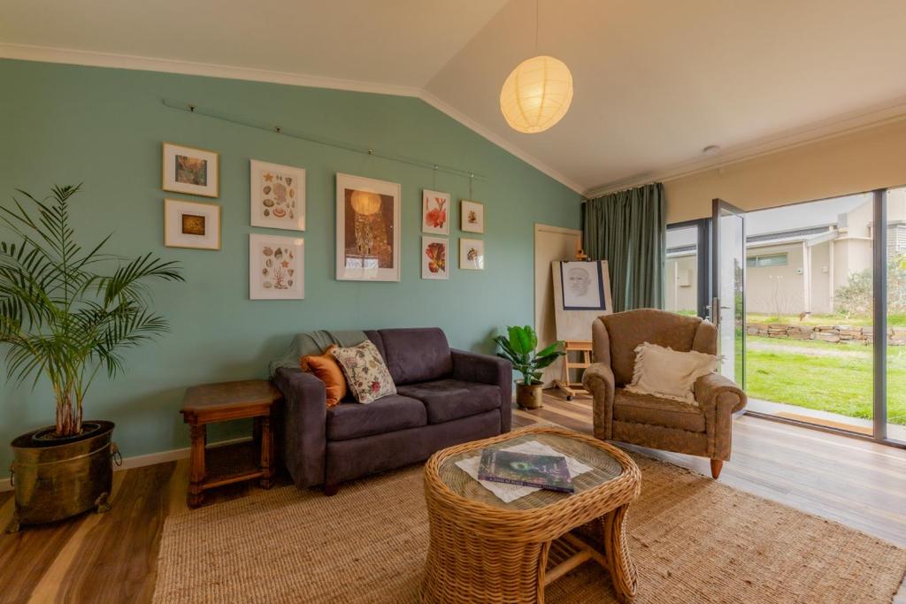 sala de estar con sofá y silla en Meander Retreat - Garden Studio, en Springton