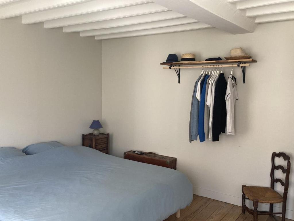 a bedroom with a bed and a rack of clothes at Maison Etretat à 50 mètres de la plage in Étretat