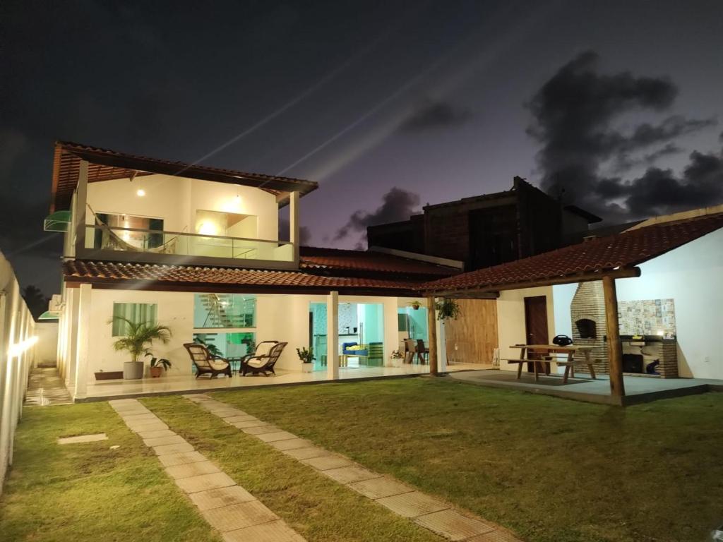 une maison avec une grande arrière-cour la nuit dans l'établissement Casa PatachAmar, à Porto de Pedras
