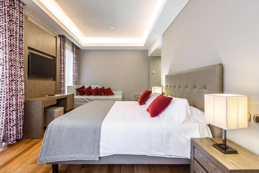 1 dormitorio con 1 cama blanca grande con almohadas rojas en Hotel Delle Nazioni en Roma