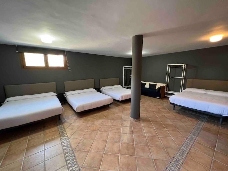 a room with three beds and a pole in it at Casa con piscina en el centro de Marbella. in Marbella