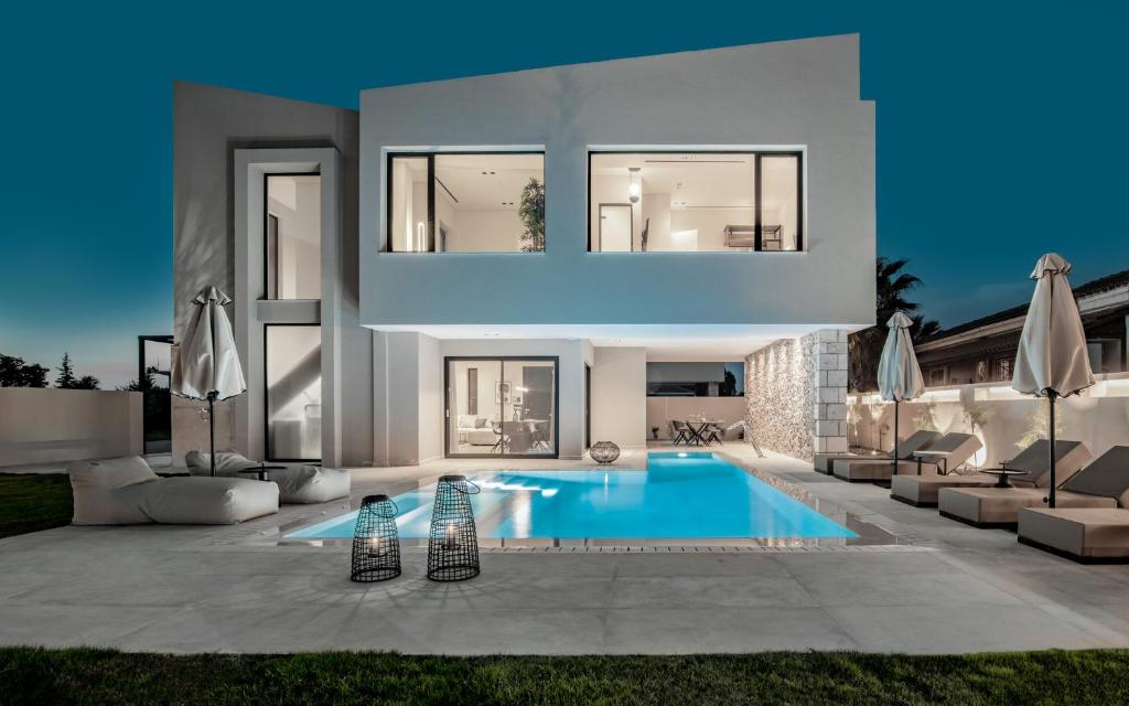 una casa grande con un patio con piscina en Vorto Luxury Villas, a Signature Island Retreat, By ThinkVilla, en Zakynthos