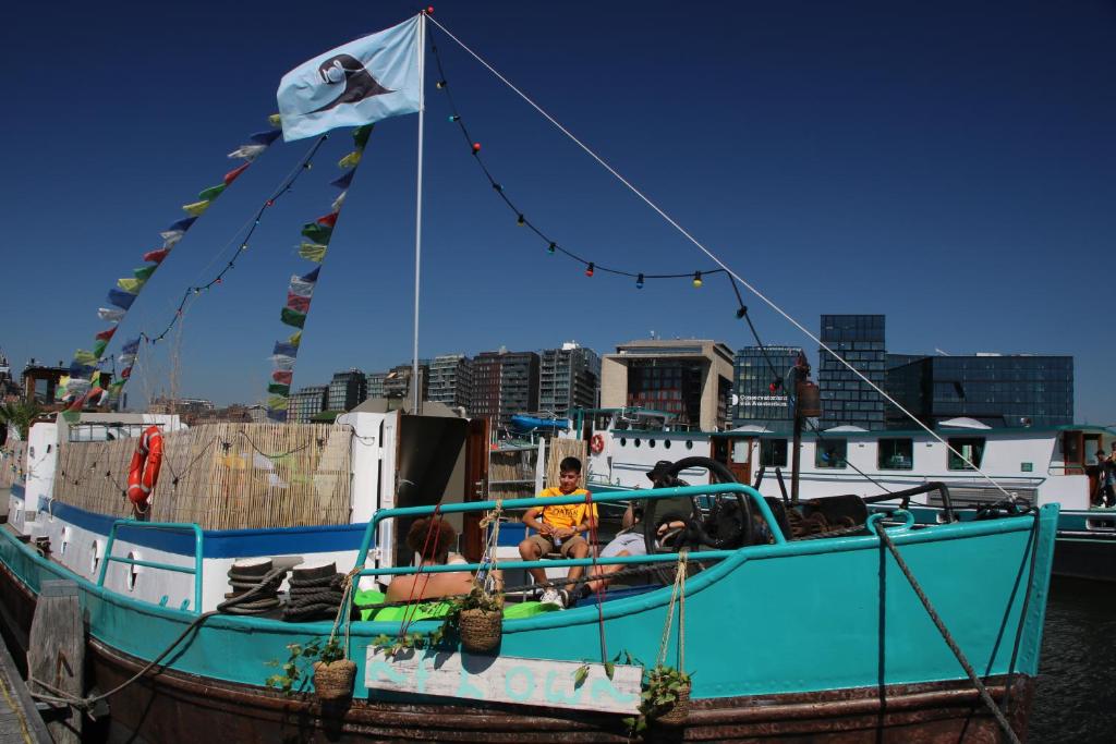 een blauwe boot met twee mensen erop bij FLOW in Amsterdam