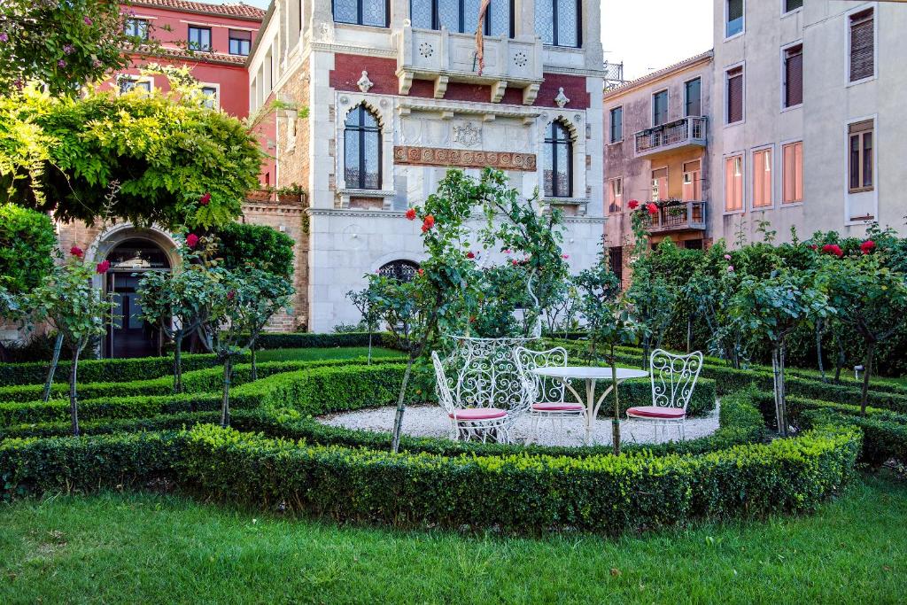 a garden with two chairs and a table in front of a building at Ca' Nigra Lagoon Resort in Venice