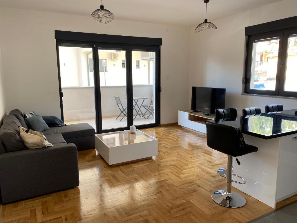 a living room with a couch and a tv at Amfora Suite in Trebinje