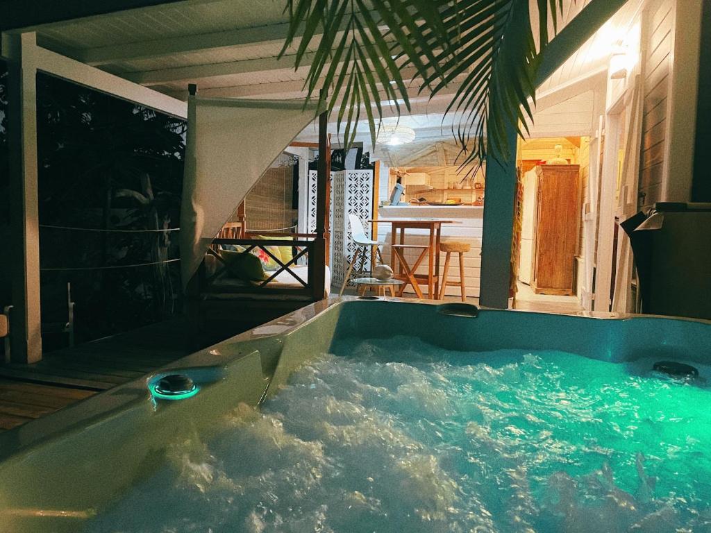 eine Whirlpool-Badewanne in der Mitte eines Hauses in der Unterkunft Bungalow Karaib Lodge in Saint-François