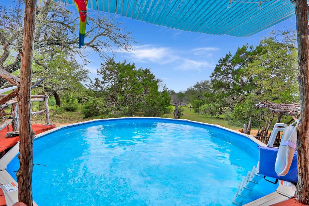 a large swimming pool with chairs and an umbrella at Three Horses Ranch in Johnson City