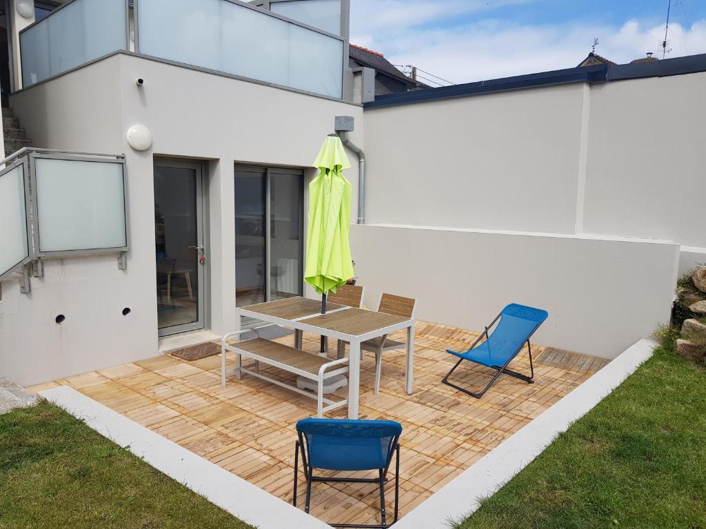 um pátio com uma mesa e 2 cadeiras em COTE JARDIN - CANCALE - GITE STANDING - PROCHE CENTRE ET PORT em Cancale