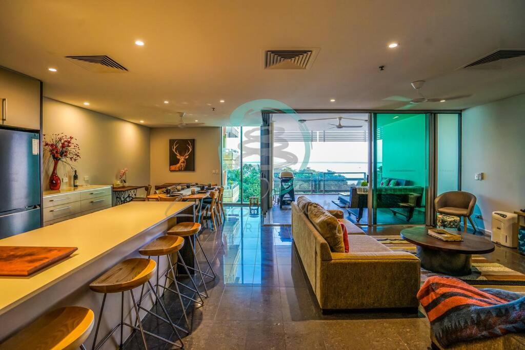 a kitchen with a bar and a living room with a couch at ZEN AT ONE30: 3-BR Luxury Corporate Long Stays in Darwin
