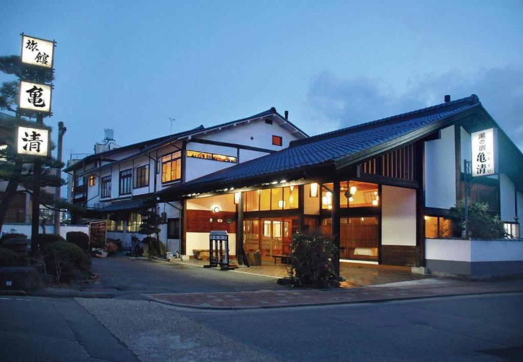 a building with a sign on the side of a street at Kamesei Ryokan in Chikuma