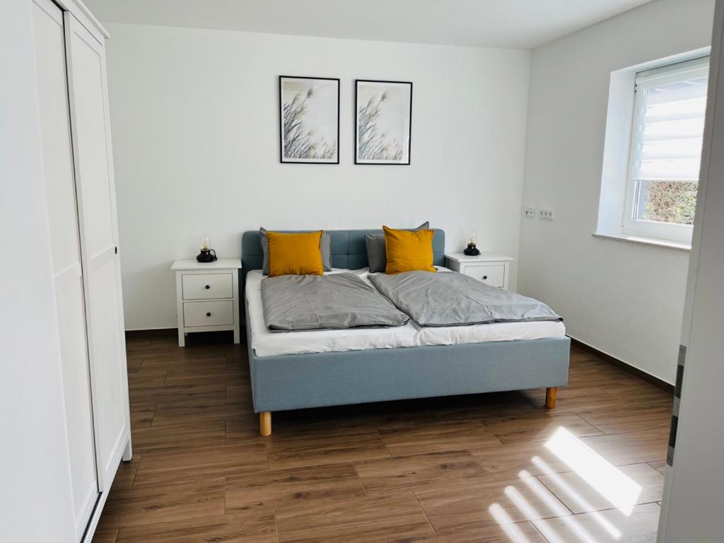 a bedroom with a bed with yellow pillows on it at Casa Caro in Prüm