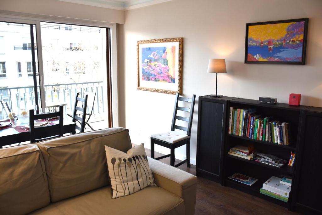 a living room with a couch and a book shelf at Porte de Versailles in Issy-les-Moulineaux