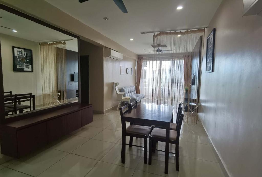 a dining room and living room with a table and chairs at Ipoh Majestic R&C Homestay 2 & 3 in Ipoh