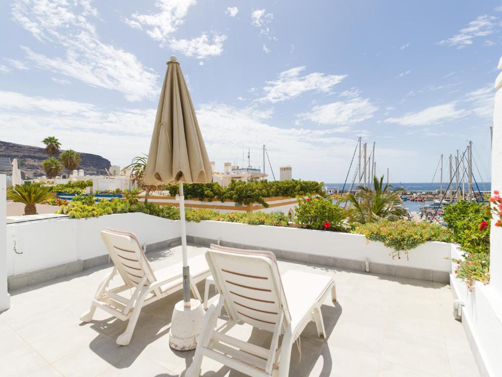 a patio with a table and chairs and an umbrella at Marina nº 53 in Puerto de Mogán