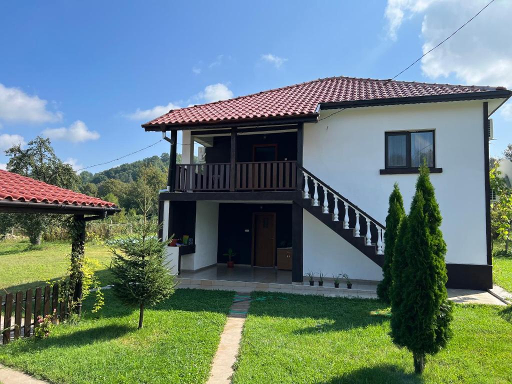 ein Haus mit einem Balkon und einem Hof in der Unterkunft Къща Ралица in Chakalarovo