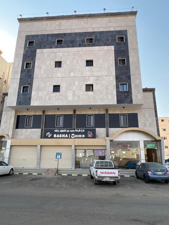 un edificio con un'auto parcheggiata in un parcheggio di دار آل زاهب للشقق المفروشه a Tabuk