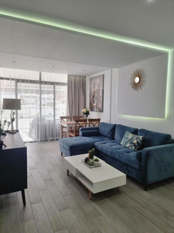 uma sala de estar com um sofá azul e uma mesa em Luxury apartment in Puerto Rico -Gran Canaria em Mogán