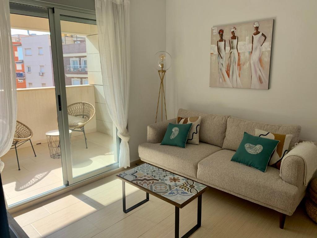 salon z kanapą i stołem w obiekcie Precioso apartamento primera línea de playa w mieście Águilas