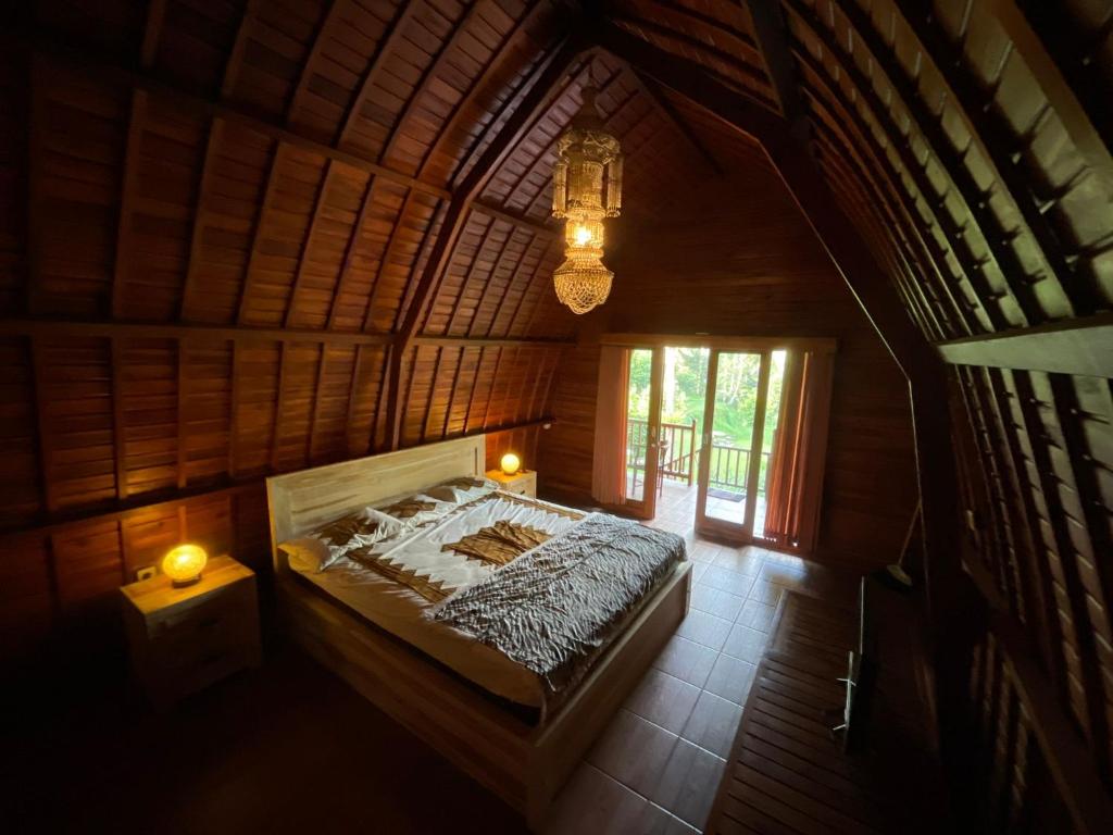 een uitzicht op een bed in een houten kamer bij Sugita Wooden House in Payangan