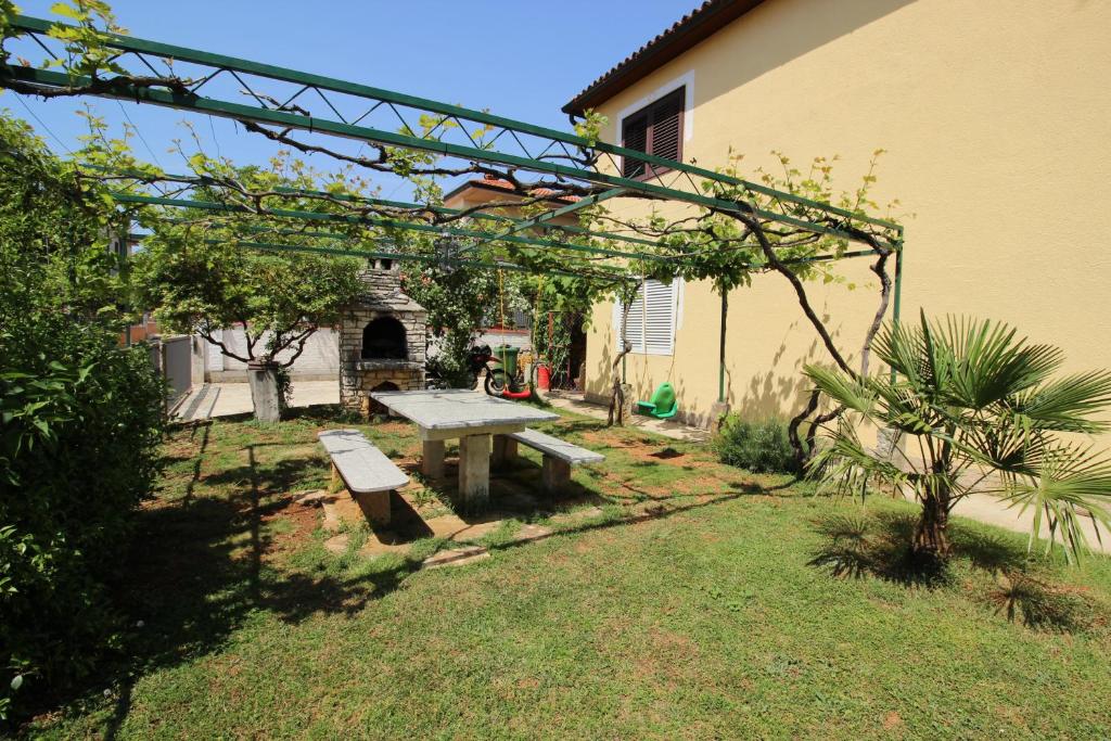 a picnic table in a yard with a building at MILAN A4, 50 m from the beach in Novigrad Istria