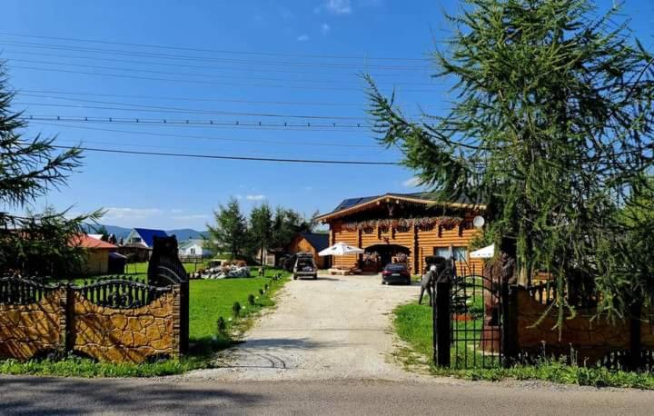 una casa con una puerta delante de una entrada en Pensiunea Laricea, en Vatra Dornei