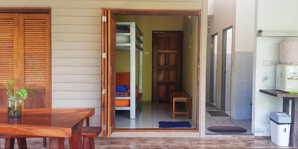 una casa con una puerta que da a una habitación con una mesa en Baan Hinlad Home and Hostel en Lipa Noi