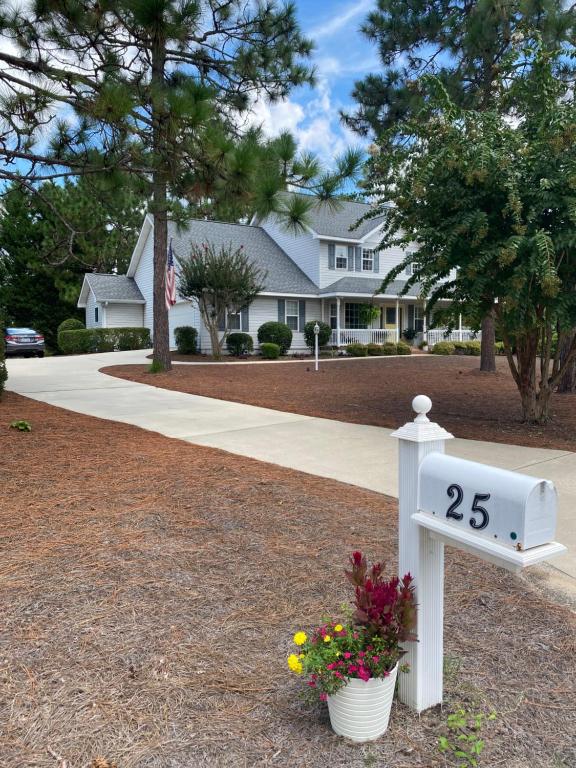 a house with a mailbox with flowers in a yard at Suite Melissa's Pinehurst Country Club #6 Private Room and Bath in Pinehurst