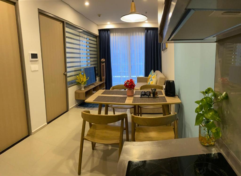 een keuken en een woonkamer met een tafel en stoelen bij Son Thuy's House -Luxury Apartment The Sóng Vũng Tàu in Vung Tau