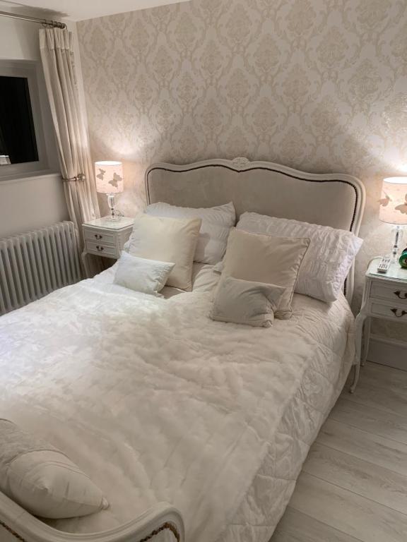a bed with white sheets and pillows in a bedroom at Coastal Joy - Room 4 in Newbiggin-by-the-Sea