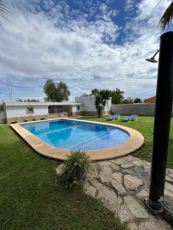 a swimming pool in the yard of a house at Chalet en La Barrosa, Piscina+BBQ+Grifo de Cerveza in Chiclana de la Frontera