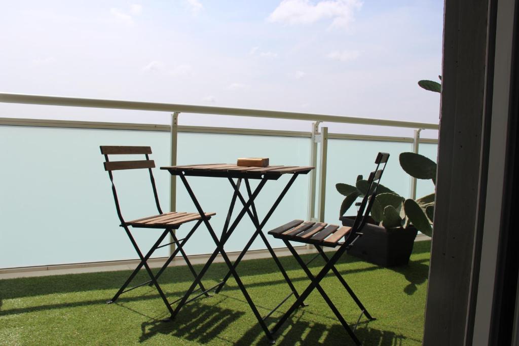 einen Tisch und Stühle auf einem Balkon mit einer Pflanze in der Unterkunft bariairport in Bari