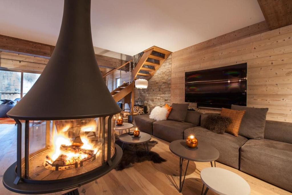 a living room with a large fireplace in the center at Chalet le Bonheur in Méribel