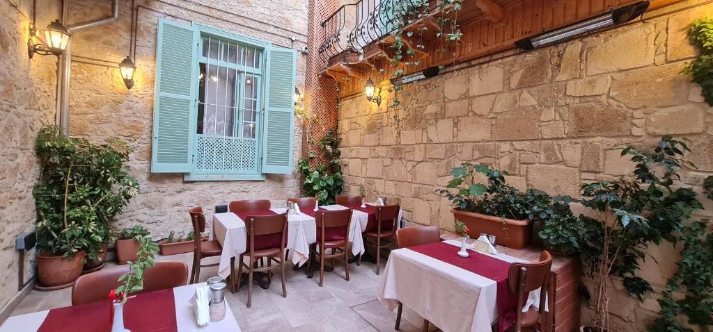 un restaurant avec des tables et des chaises et un mur en briques dans l'établissement Hotel Valide Hanim Konak, à Lefkosa Turk