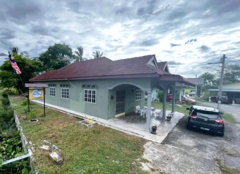 una casa con un coche aparcado delante de ella en Homestay Hassani en Kepala Batas