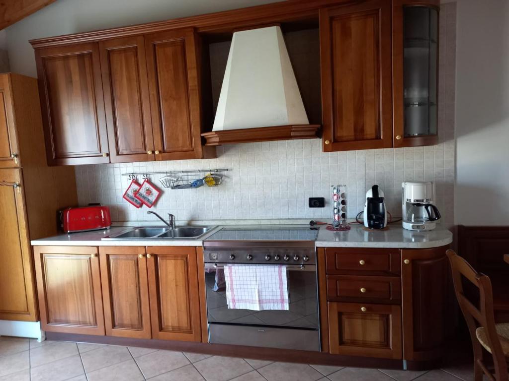 a kitchen with wooden cabinets and a stove top oven at Appartamento Fiordaliso 2 in Montichiari