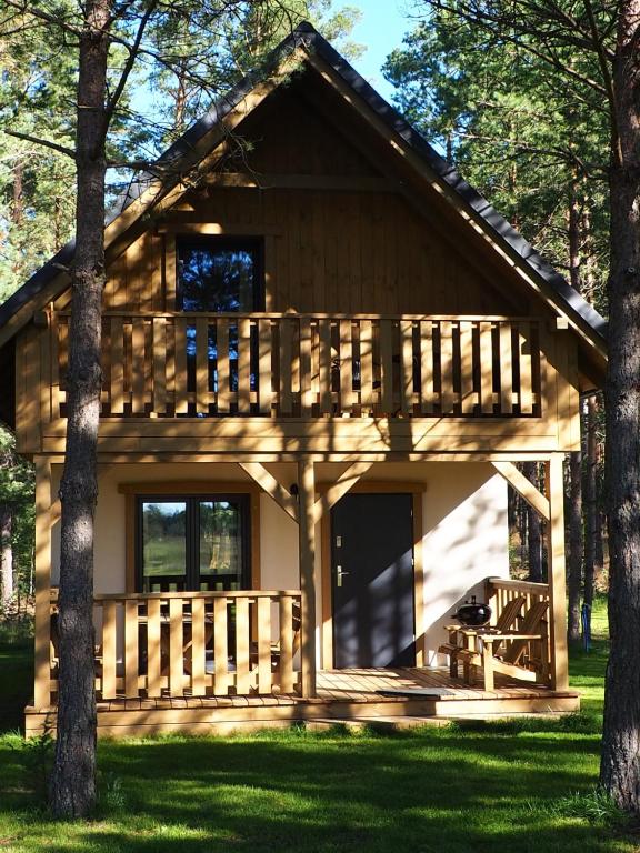 a log cabin in the woods with trees at Osada Kukówko in Wdzydze Tucholskie