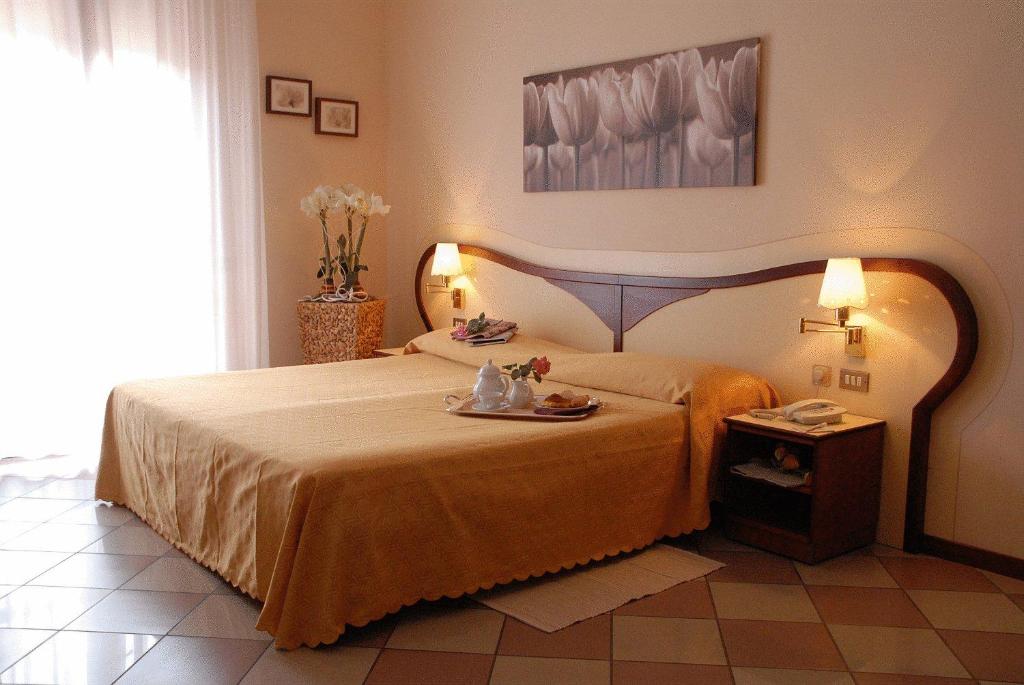 Un dormitorio con una cama y una mesa con muñecas. en Hotel La Fenice, en Formigine