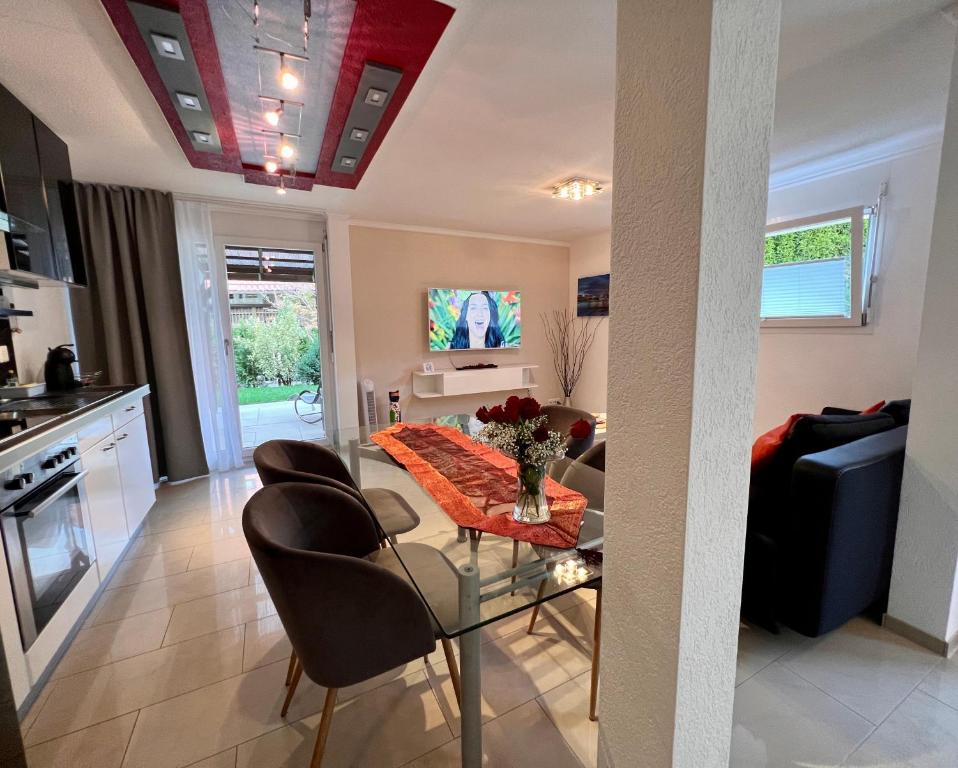 eine Küche und ein Wohnzimmer mit Tisch und Stühlen in der Unterkunft Apartment im Emmental in Oberburg