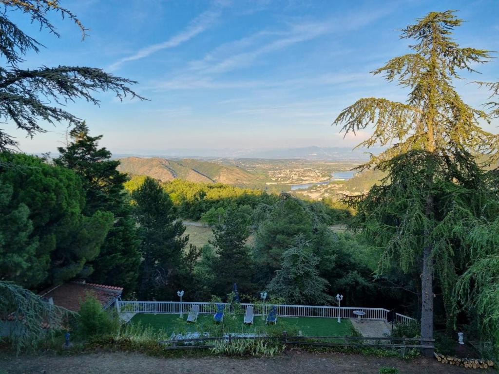 uma vista para um vale a partir de uma colina com árvores em Tikazéla - Domaine Ombre et Lumière em Saint-Jean-de-Muzols