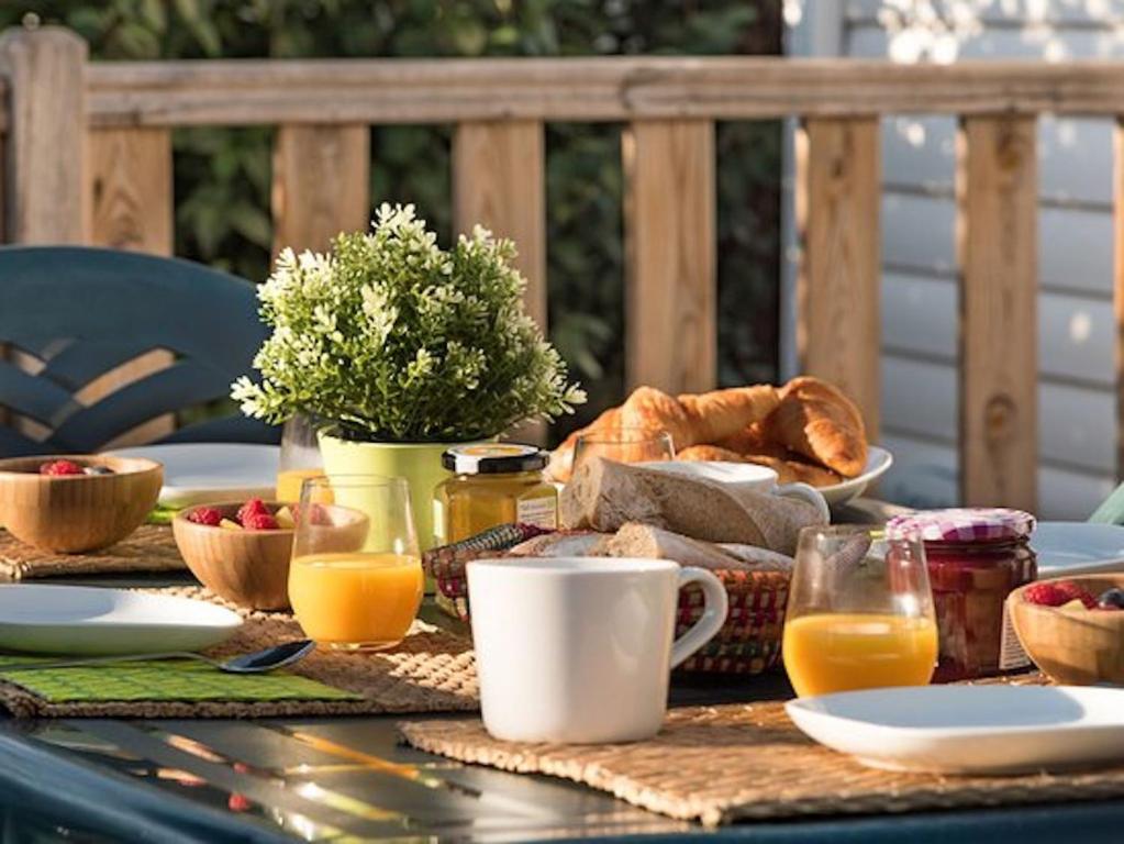 ロンス・レ・バンにあるPlaisirs Nature à La Pignadeのテーブル(朝食用食品、オレンジジュース、パン付)