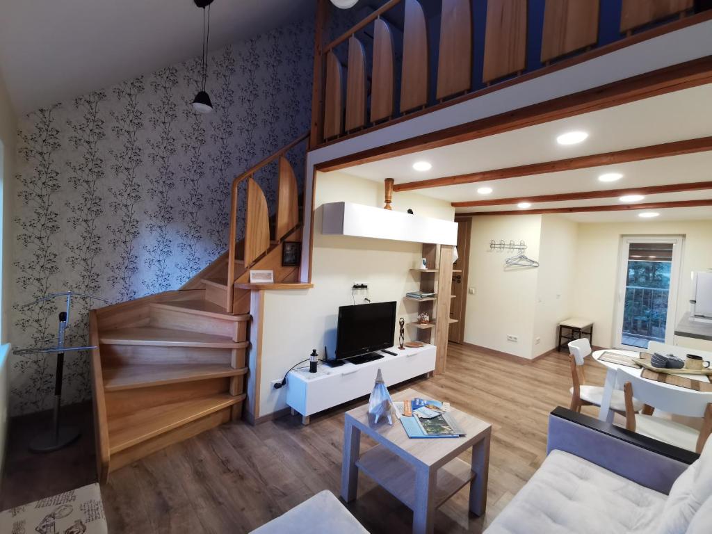 ein Wohnzimmer mit einer Treppe und einem TV in der Unterkunft Nostalgija2 in Nida