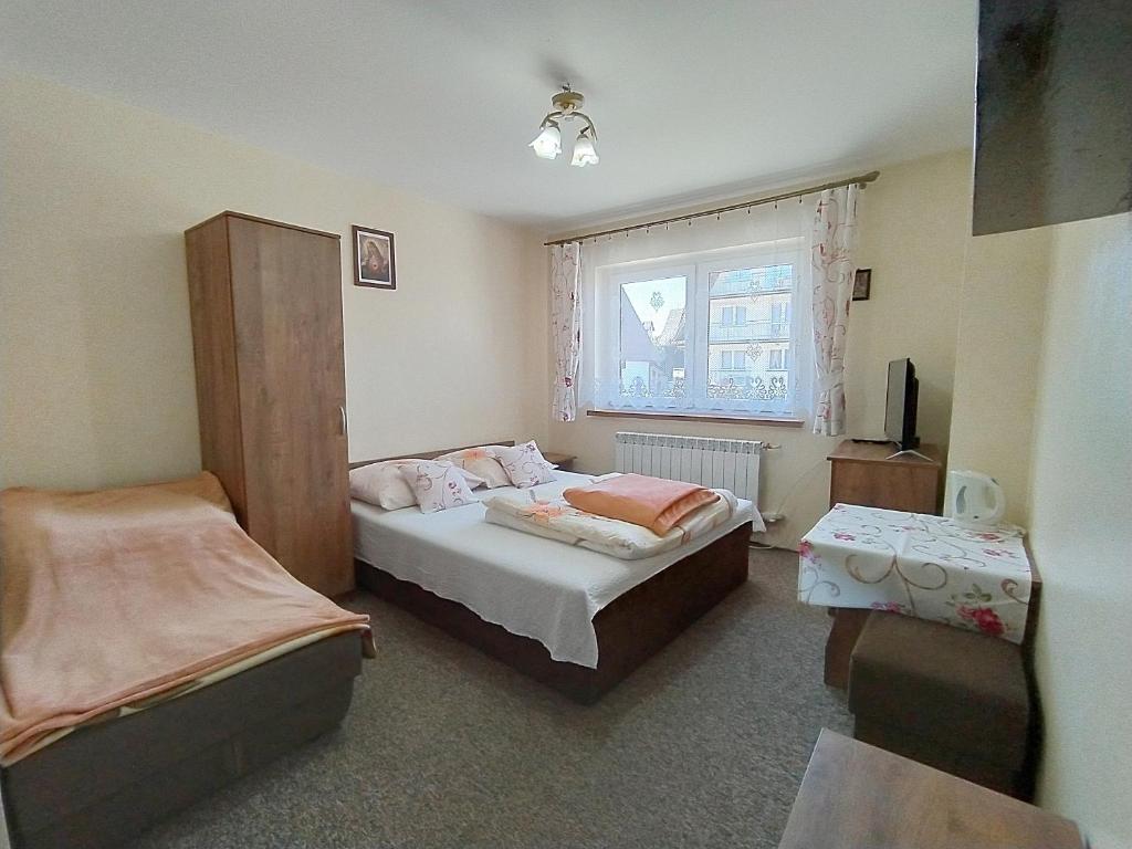 a small bedroom with a bed and a window at U Wacławików in Zakopane
