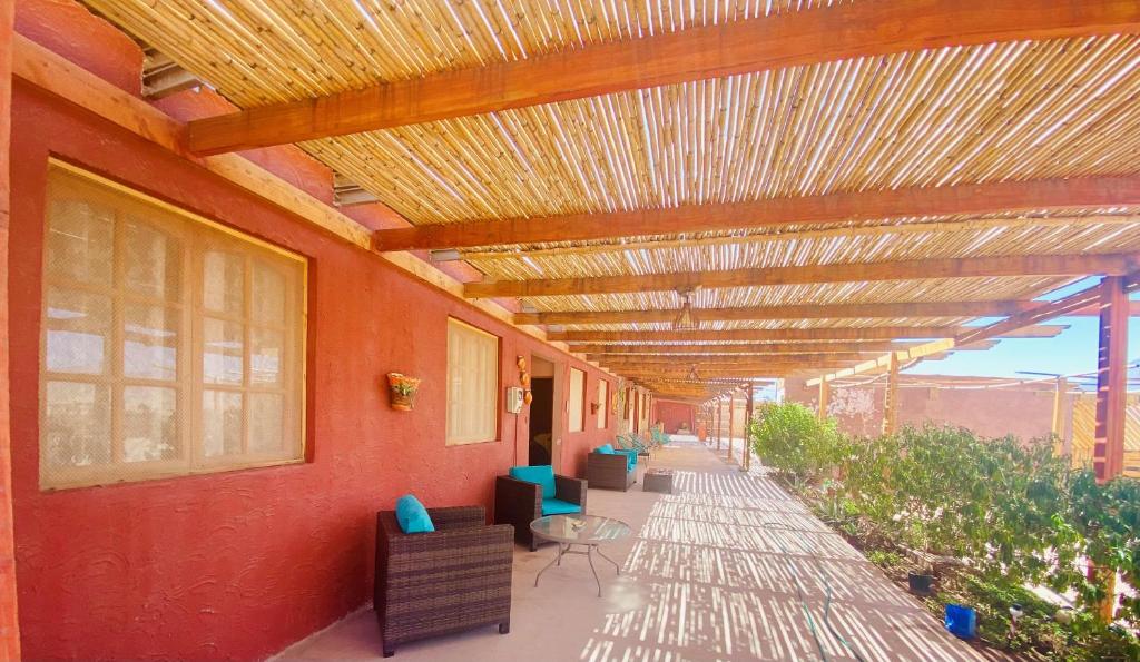 a covered walkway with chairs and tables on a building at Hostal Katari in San Pedro de Atacama